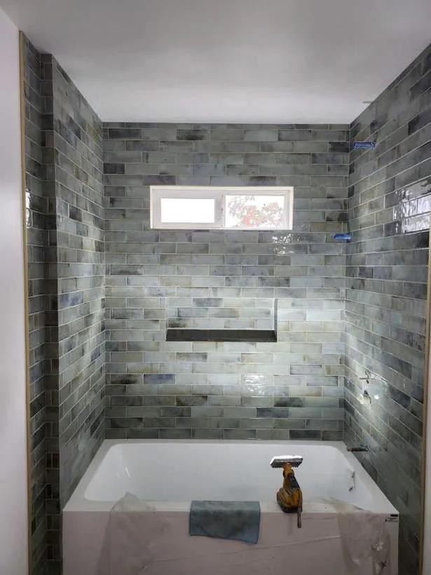 Blue-green tile tub surround mid-installation by BBJ Flooring Corp