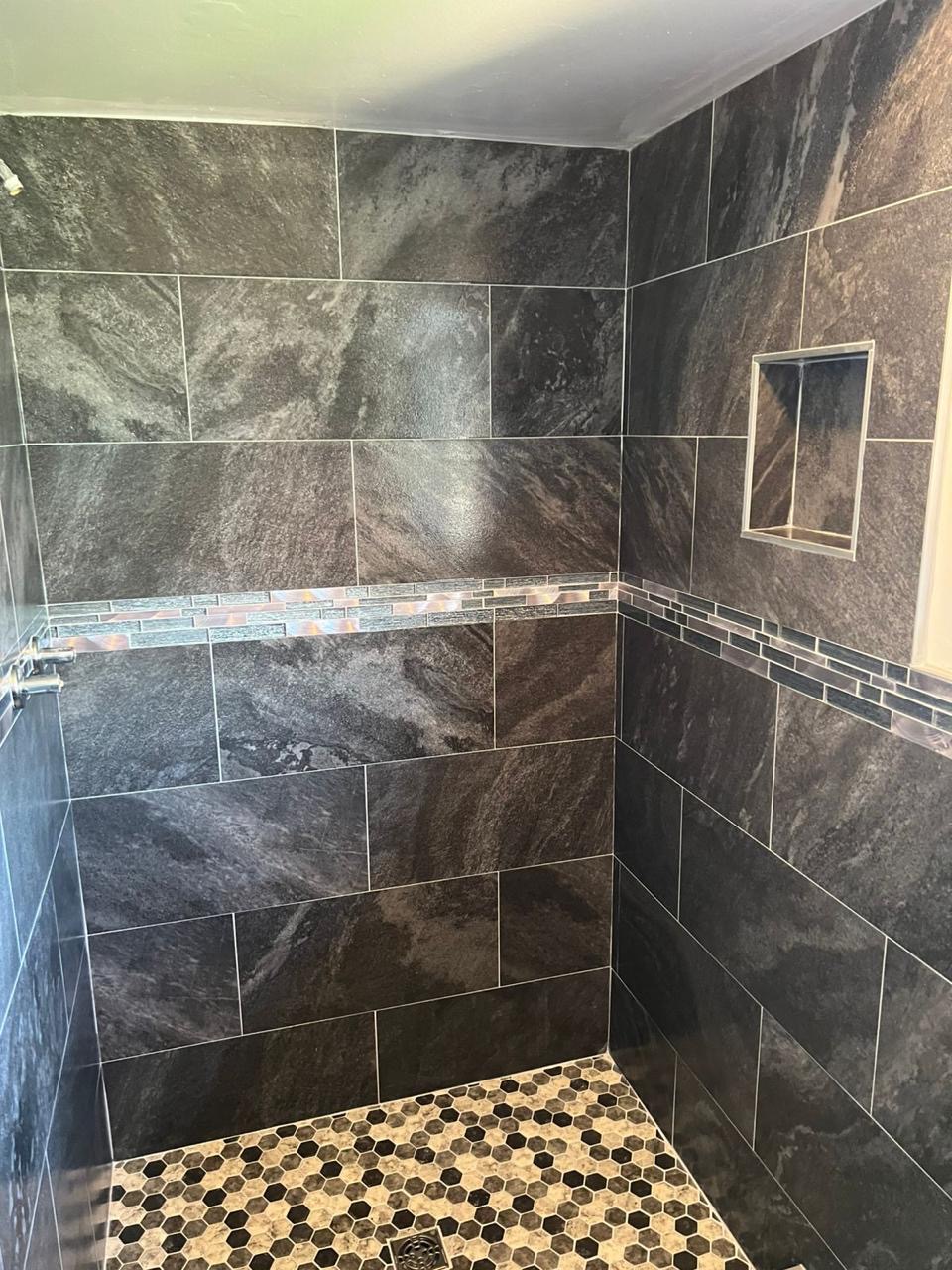 Finished dark stone-look tile shower with glass mosaic accent installed by BBJ Flooring Corp