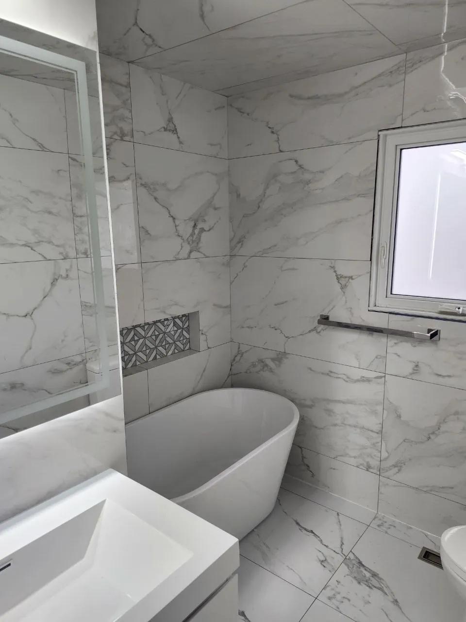 Finished marble-look bathroom with freestanding tub installed by BBJ Flooring Corp
