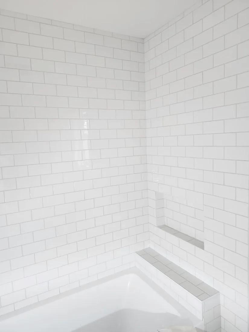 Finished white subway tile tub surround installed by BBJ Flooring Corp
